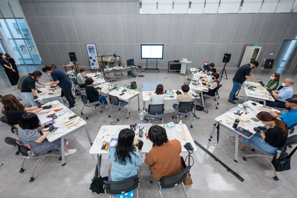 Overhead view of a hands-on classroom workshop with diverse students using hi-tech equipment.