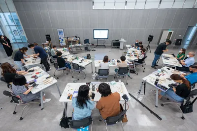 Overhead view of a hands-on classroom workshop with diverse students using hi-tech equipment.