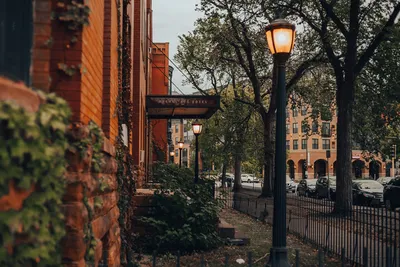 Street lamps illuminate a historic brick building street scene in Minneapolis, creating a nostalgic mood.